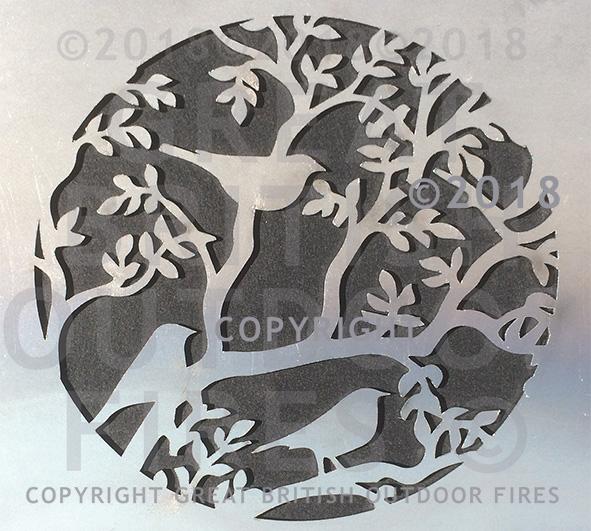 "This circluar design shows three blackbirds perched among the branches and leaves of a tree. "