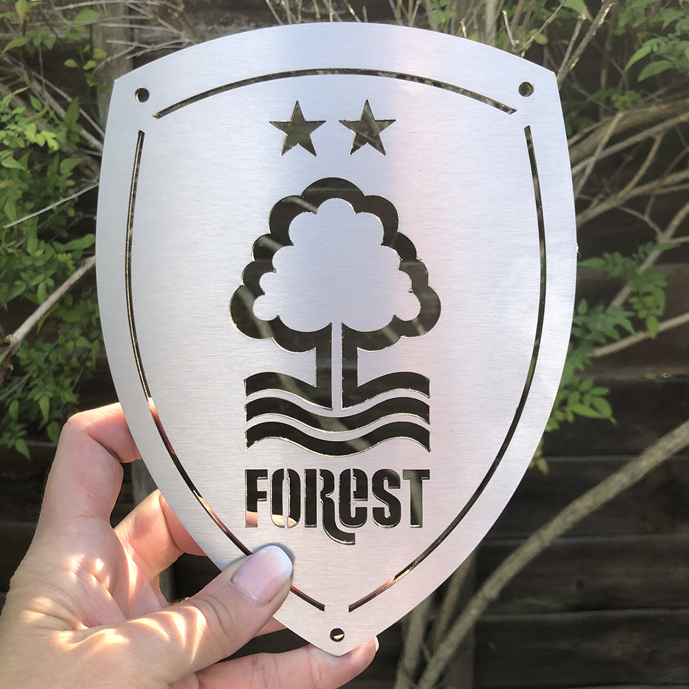 Nottingham Forest Football Club 15x20cm Stainless Steel Wall Shield by Great British Outdoor Fires in a garden